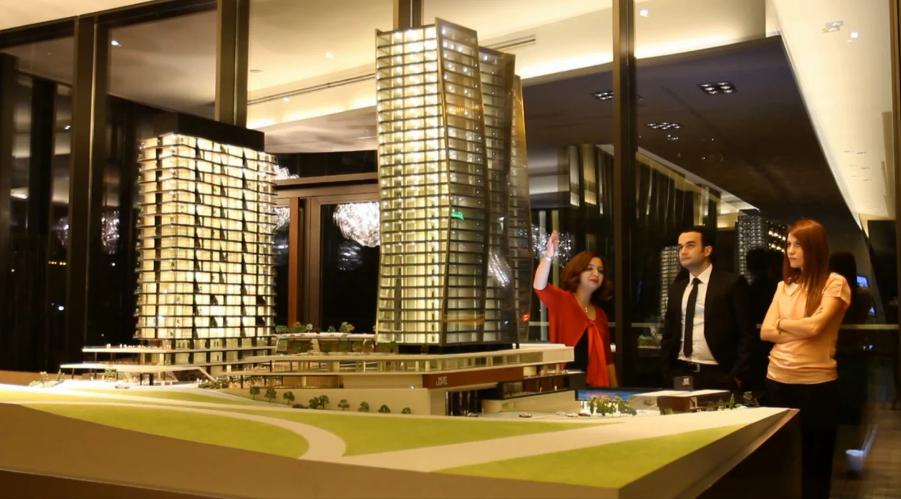 Visitors at the illuminated Next Level scale model in the sales office